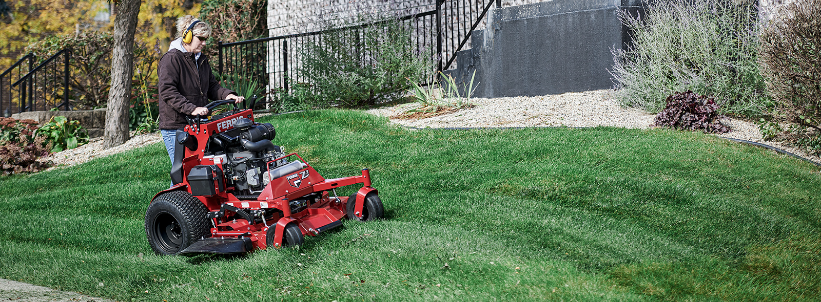 Woman standing on SRS Z3 mower cutting grass