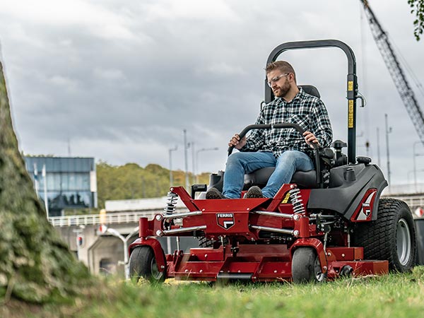 Le professionnel tond avec une tondeuse commerciale zéro turn Ferris.