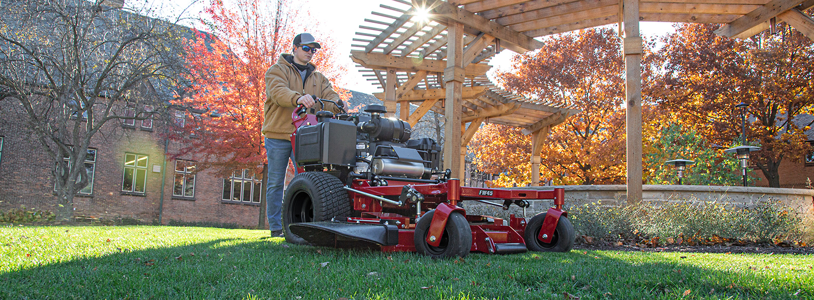 Man mowing with Ferris walk behind mower in park