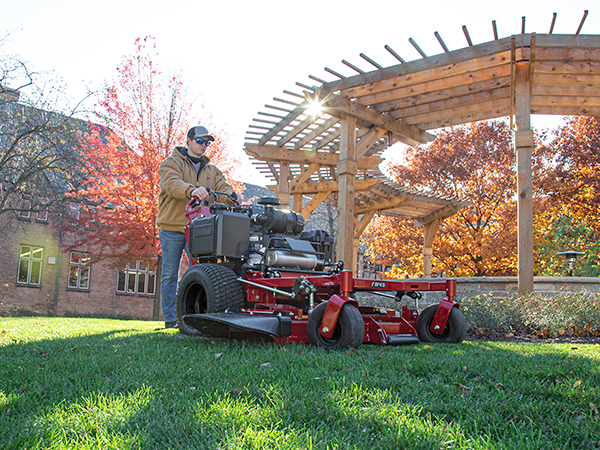 Man mowing with Ferris walk behind mower in park